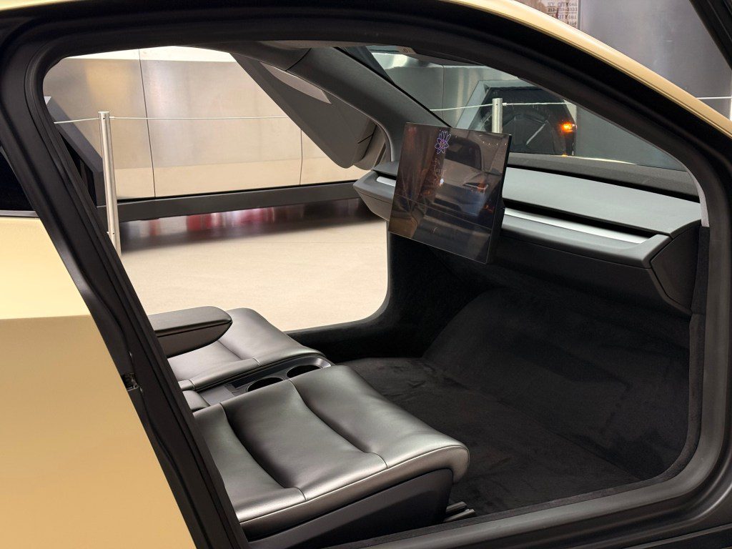 نمای داخلی تاکسی خودران Cybercab با دو صندلی چرمی، نمایشگر مرکزی و طراحی مینیمال بدون فرمان برای تجربه رانندگی خودکار