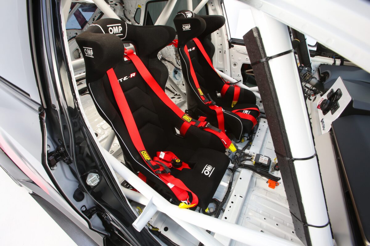 نمای داخلی کابین مسابقهای تویوتا bZ Time Attack با دو صندلی مسابقهای OMP، کمربندهای قرمز و قفس ایمنی فولادی قابل مشاهده است