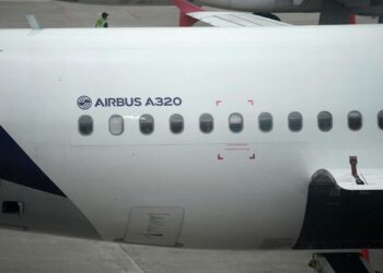 نمای نزدیک از بدنه یک هواپیمای ایرباس A320، نشان دادن نام "AIRBUS A320" و ردیفی از پنجره‌ها.