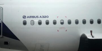 نمای نزدیک از بدنه یک هواپیمای ایرباس A320، نشان دادن نام "AIRBUS A320" و ردیفی از پنجره‌ها.