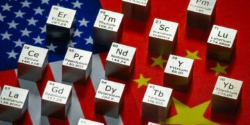 المان‌های مکعبی از عناصر خاکی کمیاب (Rare Earth Elements) که نمادهای شیمیایی مانند Nd، Pr و Er روی آن‌ها حک شده است، و بر روی ترکیبی از پرچم‌های ایالات متحده و چین قرار گرفته‌اند.