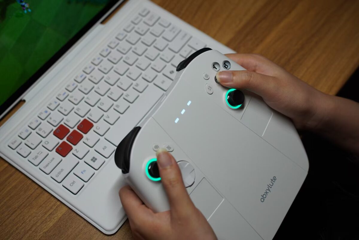 نمایی از اولین کنسول دستی سه بعدی جهان Abxylute 3D ONE در رنگ سفید در دستان یک گیمر روی کیبورد اختصاصی این کنسول