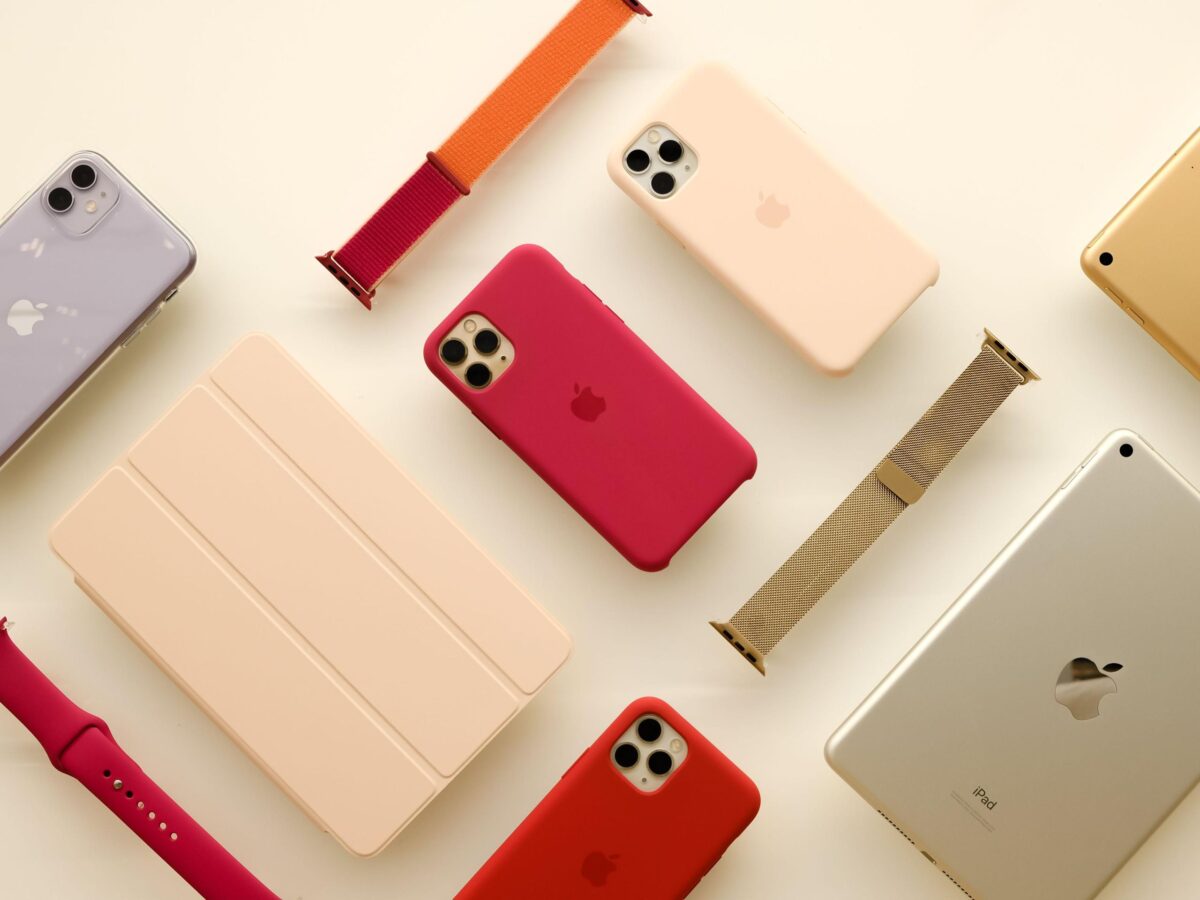 یک طرح مسطح از محصولات و لوازم جانبی اپل، شامل قاب‌های آیفون در رنگ‌های مختلف، بند اپل واچ و یک تبلت آیپد.