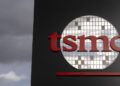 لوگوی TSMC به رنگ قرمز و سفید روی نمای سیاه یک ساختمان.