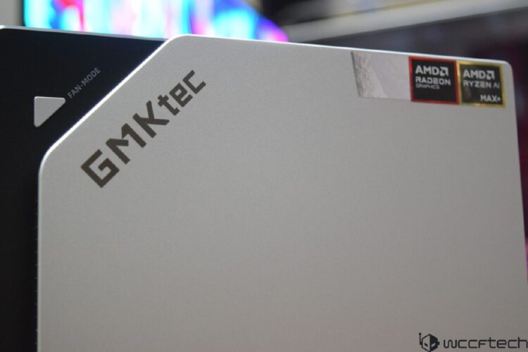 نمای نزدیک از یک مینی کامپیوتر یا کیس رومیزی نقره‌ای GMKtec با آرم‌های AMD Radeon Graphics و AMD Ryzen AI MAX+ در بالا سمت راست.