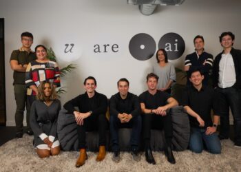 عکس گروهی از کارمندان استارتاپ هوش مصنوعی "u are • ai" (که قبلاً Eternos بوده) در مقابل دیوار شرکت، که برخی نشسته‌اند و برخی ایستاده‌اند.