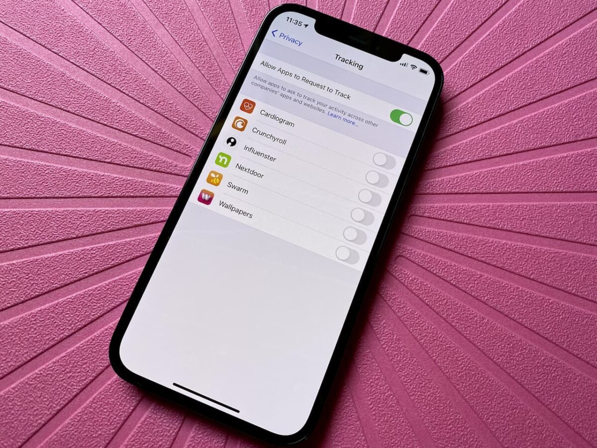 اسکرین‌شات از صفحه تنظیمات ردیابی (Tracking) در آیفون که در پس‌زمینه صورتی با طرح پرتو قرار دارد و گزینه "Allow Apps to Request to Track" فعال است.