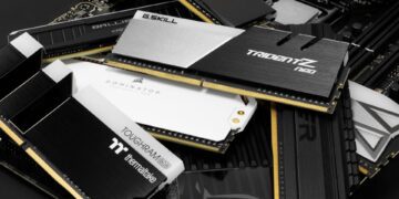 آرایشی از ماژولهای حافظه رم (RAM) با طرحهای مختلف هیتسینک (Heat Sink) در رنگهای سفید، سیاه و طلایی، که برندهایی مانند Corsair، G.Skill، Ballistix و Thermaltake روی آنها دیده میشود.