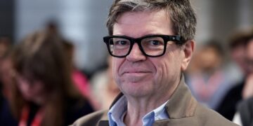 نمای نزدیک از چهره یان لکان (Yann LeCun)، دانشمند ارشد هوش مصنوعی متا، با عینک‌های مشکی و موهای خاکستری، که لبخندی ملایم دارد.