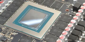 نمای نزدیک از یک تراشه GPU (احتمالاً انویدیا) که در مرکز آن یک قالب (Die) با حاشیه فیروزه‌ای دیده می‌شود و چیپ‌های حافظه اطراف آن نصب شده‌اند.