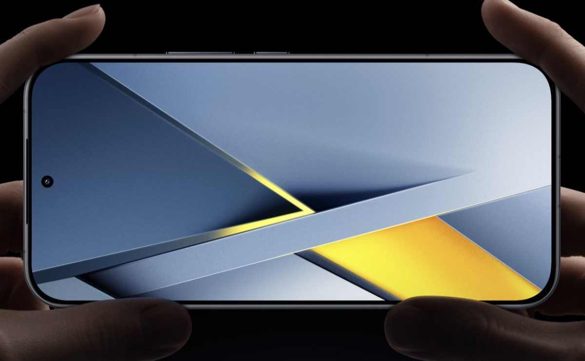 گوشی Poco در دست که صفحه نمایش آن یک تصویر زمینه انتزاعی با الگوهای آبی، خاکستری و زرد روشن را با سوراخ دوربین (Hole-punch) در گوشه بالا سمت چپ نمایش میدهد.