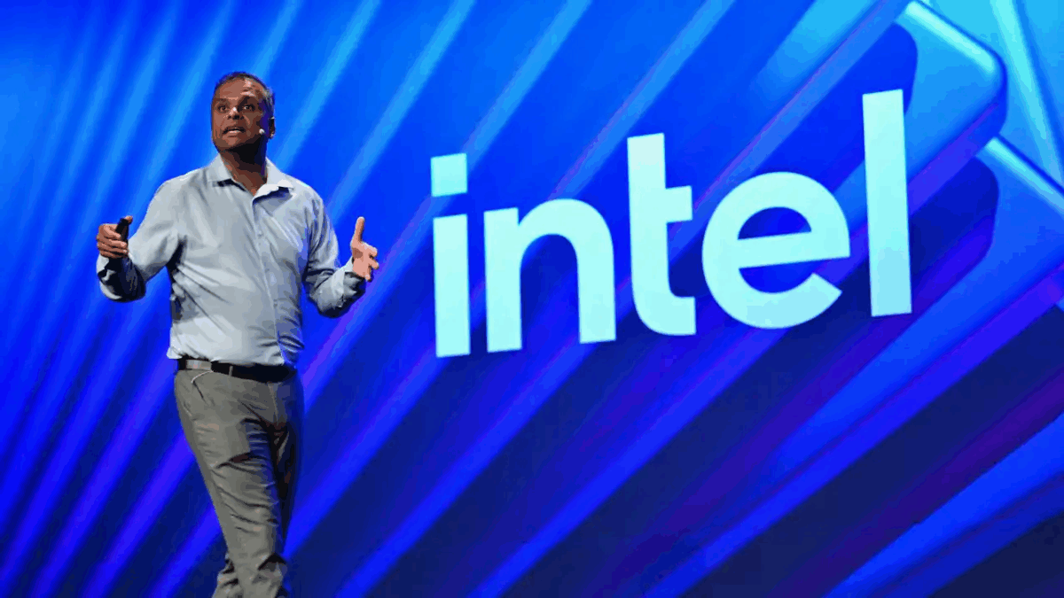 ساچین کاتی در حال سخنرانی روی صحنه، با یک میکروفون در دست و ژست دست باز، با لوگوی بزرگ "intel" با پس‌زمینه آبی روشن.