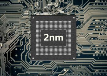 یک تراشه نیمه‌رسانا (Semiconductor chip) با متن بزرگ "2nm" در وسط، که بر روی یک برد مدار چاپی (PCB) با بافت شبکه سیاه و سفید قرار دارد.