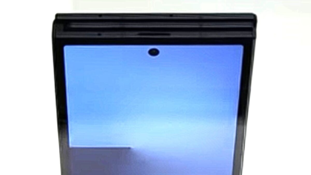 نمای نزدیک از قسمت بالای یک گوشی تاشو سه‌لته‌ای در حالت بسته، که سوراخ دوربین (Hole-punch) جلویی و شکاف‌های آن بین سه لایه تا شده دیده می‌شود.