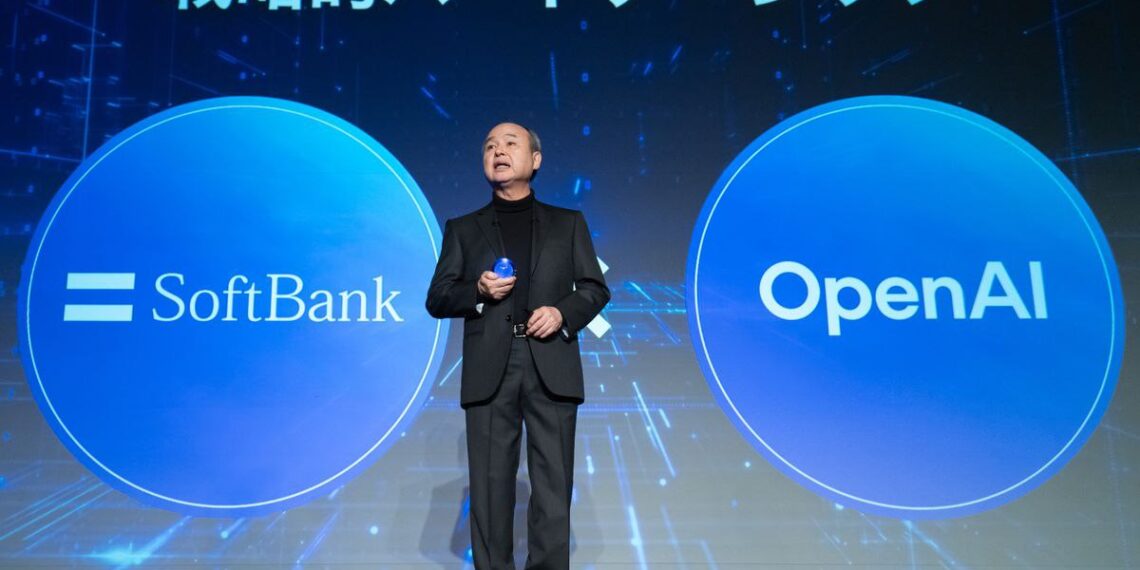 ماسایوشی سان، مدیرعامل سافت‌بانک، با کت و شلوار در حال سخنرانی روی صحنه، که در دو طرف او دایره‌های بزرگ آبی با لوگوی "SoftBank" و "OpenAI" نمایش داده شده است.