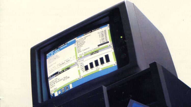 یک کامپیوتر قدیمی با مانیتور CRT که رابط کاربری گرافیکی ویندوز ۱.۰۱ را نمایش می‌دهد و برنامه‌هایی مانند Microsoft Multiplan و یک چارت نواری در آن دیده می‌شود.