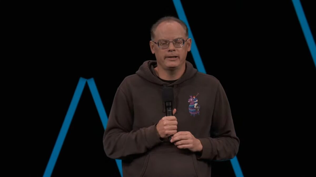 تیم سوینی (Tim Sweeney)، مدیرعامل Epic Games، با هودی قهوه‌ای و عینک در حال صحبت با میکروفون در یک کنفرانس.