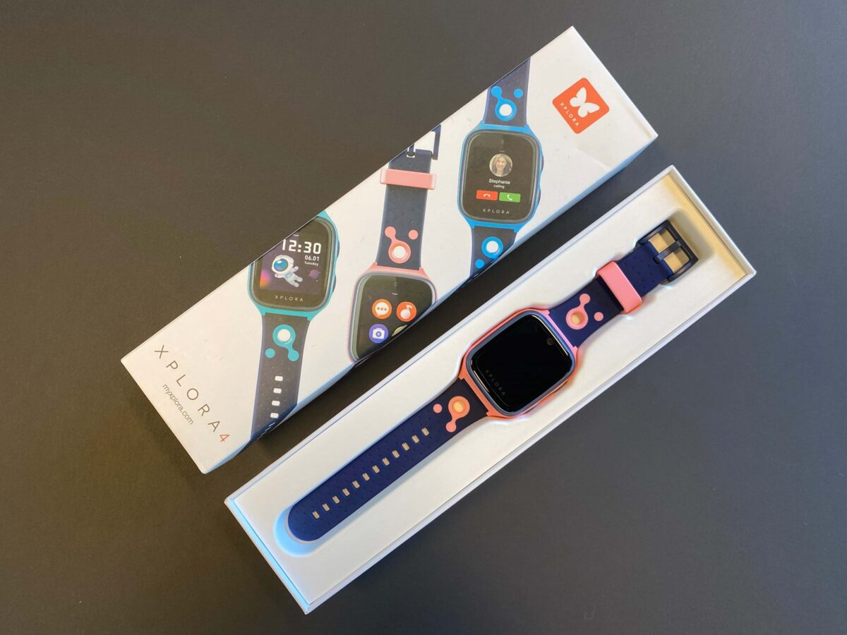 ساعت هوشمند کودکانه برند Xplora با بند سرمه‌ای و صورتی داخل جعبه بسته‌بندی.