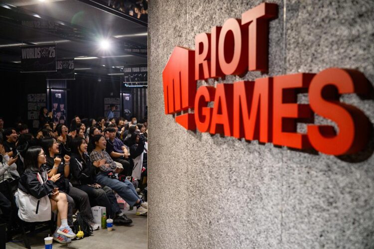 نمای داخلی رویداد League of Legends با تمرکز بر لوگوی Riot Games روی دیوار و فضای سالن، مرتبط با برگزاری ایونت رسمی، مسابقات یا برنامه‌ های رقابتی Worlds