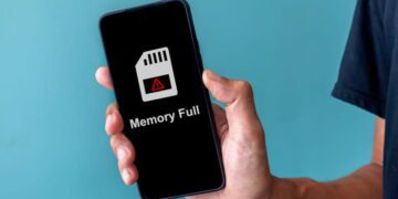 نمای گوشی هوشمند در دست کاربر با پیام هشدار Memory Full روی صفحه، نماد پر شدن حافظه داخلی و مشکلات مدیریت فضای ذخیرهسازی موبایل