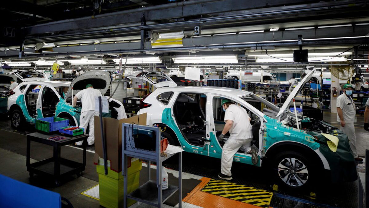 فضای داخلی خط مونتاژ خودرو با چندین خودرو نیمهکامل روی خط تولید، تجهیزات فنی، ابزارهای صنعتی و مراحل مختلف نصب قطعات بدنه و کابین