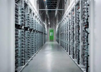 نمای راهروی مرکز داده با ردیف‌ رک‌های سرور صنعتی، کابل‌کشی ساخت‌یافته و تجهیزات خنک‌سازی، نمایش زیرساخت پردازش و ذخیره‌سازی داده در مقیاس بزرگ