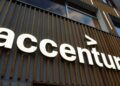 تابلوی برجسته و روشن لوگوی Accenture نصب شده بر روی نمای چوبی ساختمان.