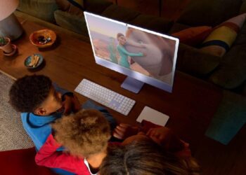 کودکان در حال تماشای انیمیشن روی آی‌مک ۲۴ اینچی بنفش رنگ.