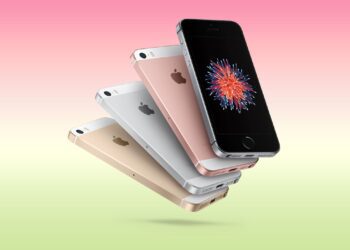 چهار گوشی هوشمند iPhone SE اصلی (طلا، نقره، رزگلد و خاکستری فضایی) در پس‌زمینه‌ای با شیب ملایم صورتی و سبز.