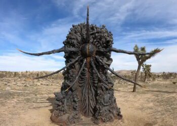 مجسمه عظیم و تیره‌رنگ با طراحی فرازمینی و شاخک‌های متعدد در دل کویر، با جزئیات ارگانیک و الهام‌گرفته از موجودات اسطوره‌ای