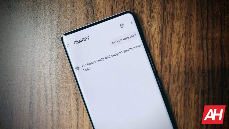 گوشی هوشمند روی میز چوبی که صفحه چت با هوش مصنوعی ChatGPT را نمایش میدهد.