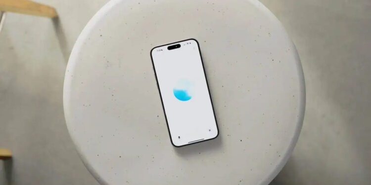 نمای بالاسری از یک گوشی هوشمند قرارگرفته روی میز گرد روشن با رابط کاربری ChatGPT Voice، نمایش انیمیشن صوتی آبی‌رنگ و اشاره به قابلیت مکالمه صوتی پیشرفته هوش مصنوعی