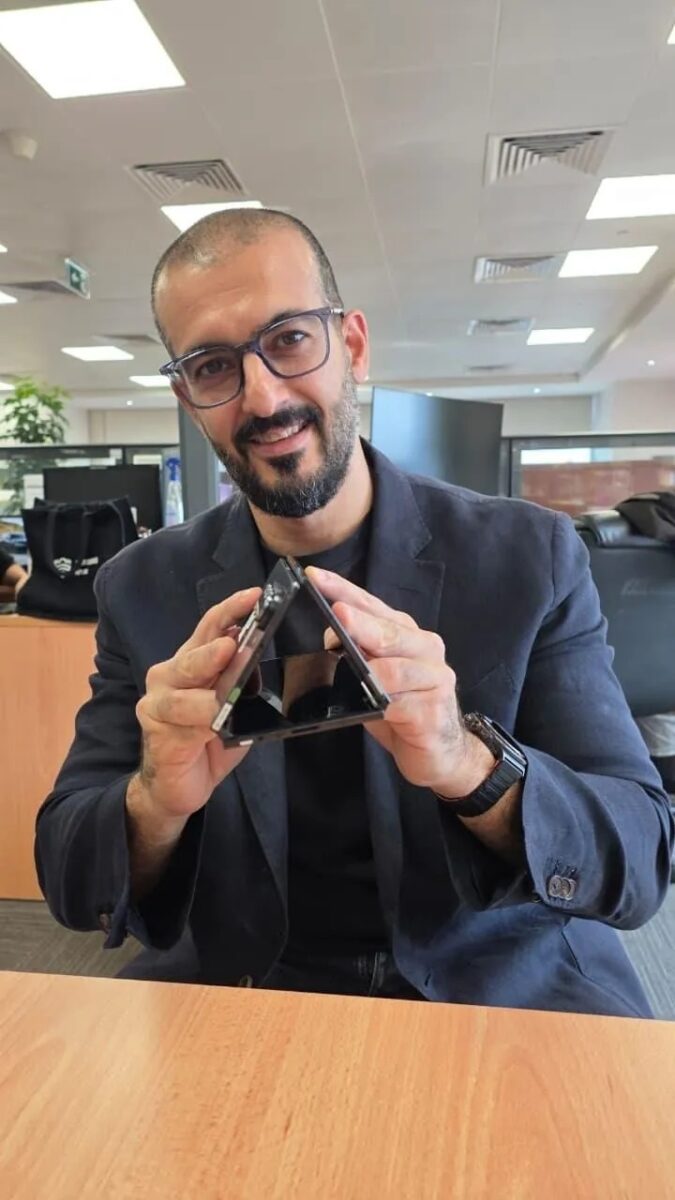 گوشی سه لایه سامسونگ که به شکل مثلثی (حالت چادر) روی میز قرار گرفته است.