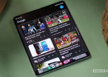 نمایشگر یک گوشی تاشو (Foldable) که فید ویدیوهای گوگل یا یوتیوب را با تصاویر بندانگشتی نشان می‌دهد.