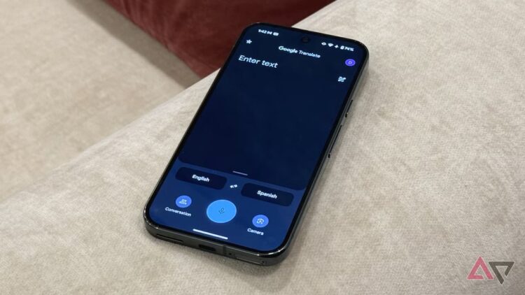 گوشی هوشمند روی مبل که صفحه اصلی اپلیکیشن گوگل ترنسلیت را نشان میدهد.