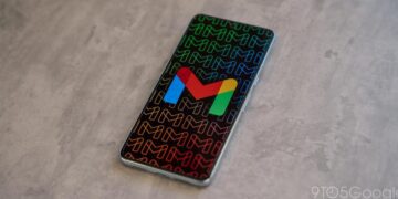 گوشی هوشمندی که آیکون رنگی جیمیل را روی پس‌زمینه‌ای با الگوی تکرار شونده حرف M نشان می‌دهد.