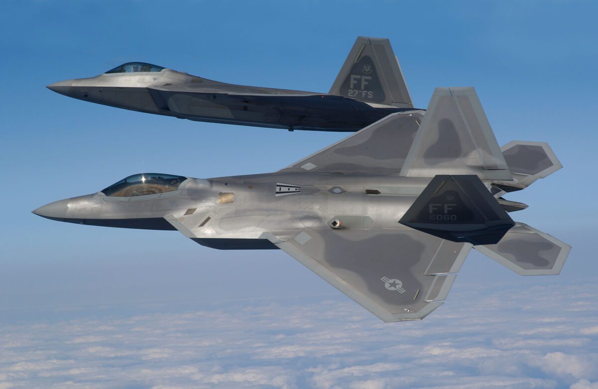 و جنگنده F-22 Raptor در حال پرواز هماهنگ بر فراز ابرها