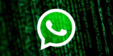 لوگوی سفید واتس‌اپ روی پس‌زمینه‌ای تیره با کدهای دیجیتالی سبز رنگ به سبک ماتریکس.