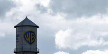 برج آب با لوگوی برادران وارنر (WB) در زیر آسمان ابری.