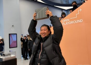 حضور بازدیدکنندگان در رویداد نمایش فناوری سامسونگ، در حال نمایش جعبه یک دستگاه تاشوی جدید مقابل غرفه رسمی با شعار OPEN PLAYGROUND