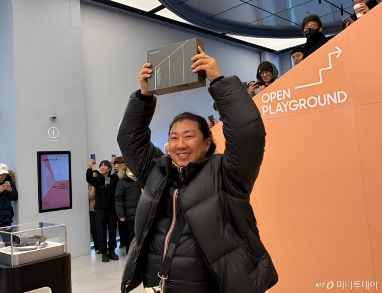 حضور بازدیدکنندگان در رویداد نمایش فناوری سامسونگ، در حال نمایش جعبه یک دستگاه تاشوی جدید مقابل غرفه رسمی با شعار OPEN PLAYGROUND