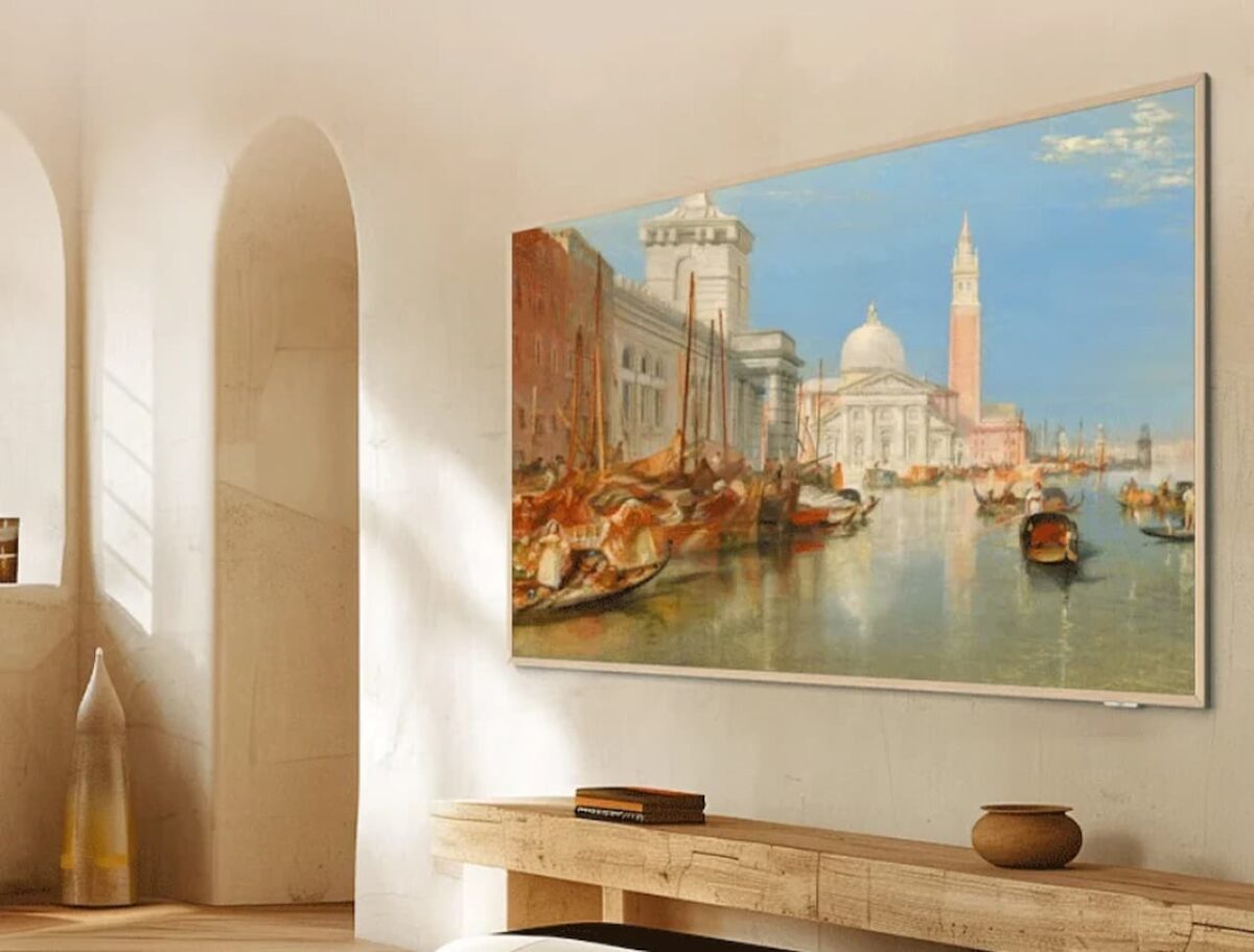 تلویزیون قابدار TCL نصب شده روی دیوار اتاق نشیمن که نقاشی کلاسیک ونیز را نشان میدهد.