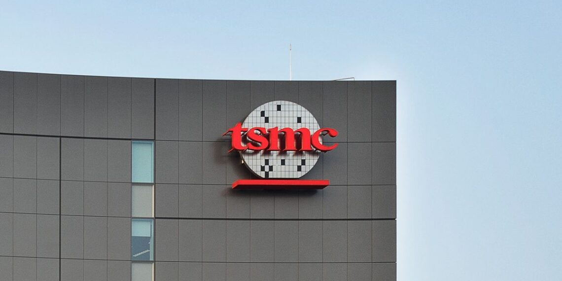 نمای خارجی یک ساختمان مدرن که لوگوی قرمز رنگ شرکت TSMC روی دیواره خاکستری آن نصب شده است.