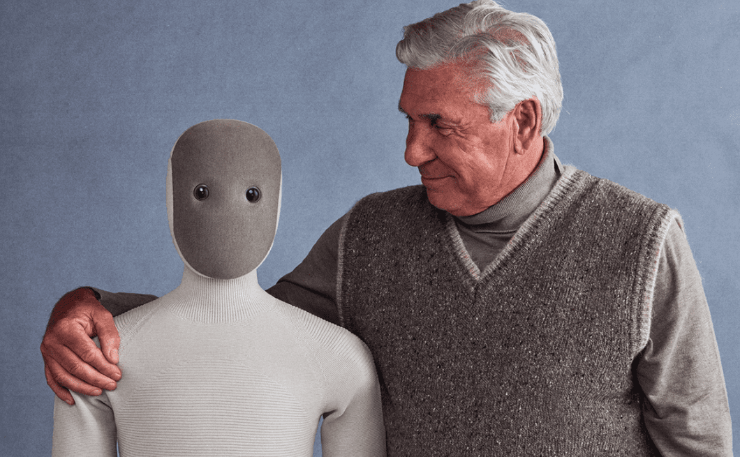 تصویری از یک ربات انسان‌نمای تسلا که در کنار یک مرد ایستاده است.