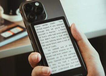 یک کتاب‌خوان الکترونیکی کوچک و مغناطیسی متصل به پشت آیفون، که متن کتاب را نمایش می‌دهد.