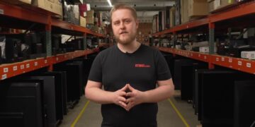 کارشناس وب‌سایت RTINGS.com در میان قفسه‌های آزمایشگاه بررسی دوام و کیفیت تلویزیون‌ها.