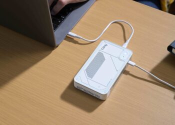 دستگاه پردازشگر کوچک هوش مصنوعی Tiiny متصل به لپ‌تاپ روی میز کار.