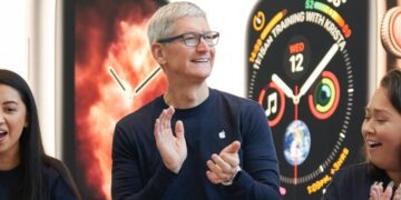 تصویر تیم کوک، مدیرعامل اپل، در حال لبخند زدن و تشویق در مقابل پس‌زمینه‌ای از اپل واچ.