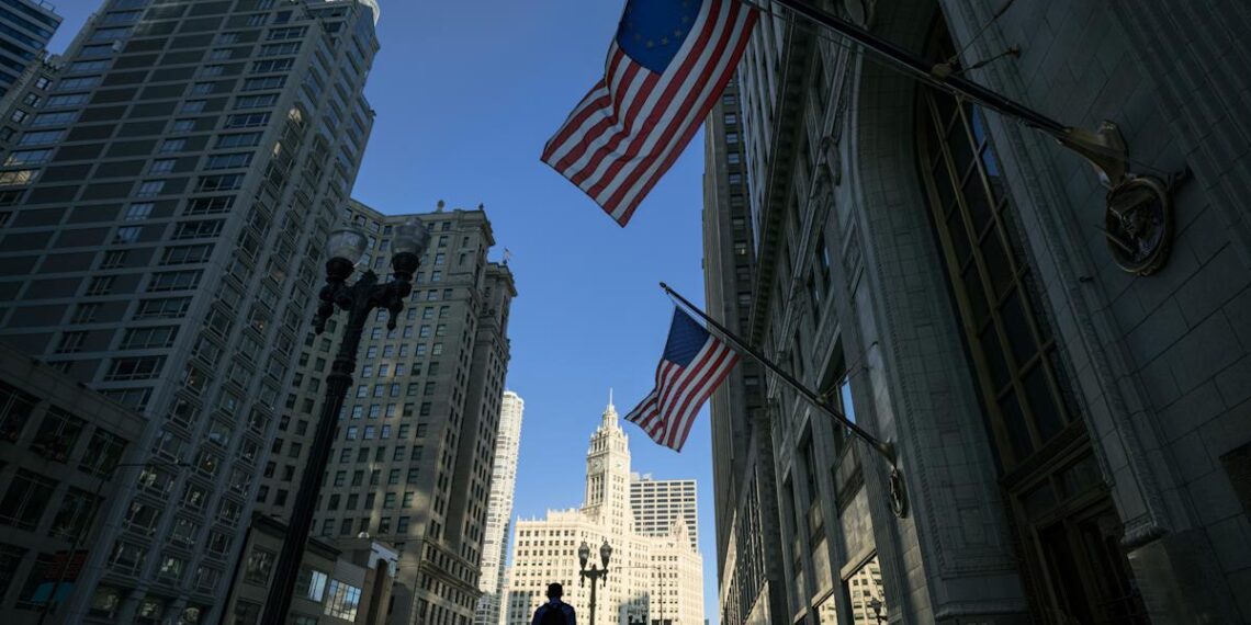 نمای پایین به بالای آسمان‌خراش‌های شهری که پرچم‌های ایالات متحده و اتحادیه اروپا از ساختمان‌ها آویزان شده‌اند.