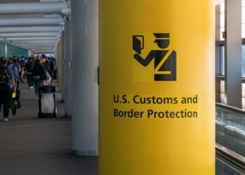 ستون زرد رنگ در فرودگاه با علامت و نوشته «حفاظت از مرز و گمرک ایالات متحده» (U.S. Customs and Border Protection).